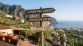 Älteres Wanderpaar steht vor Holzhinweisschilder auf La Palma/ La Palma Auswanderer